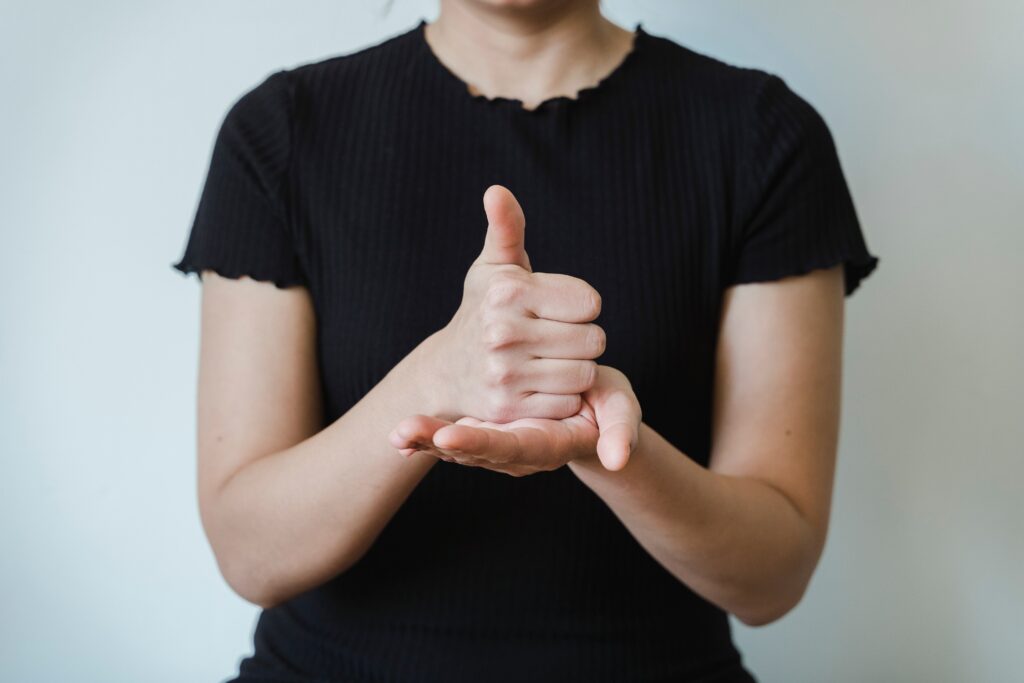 person in a black t-shirt signing the word "help"